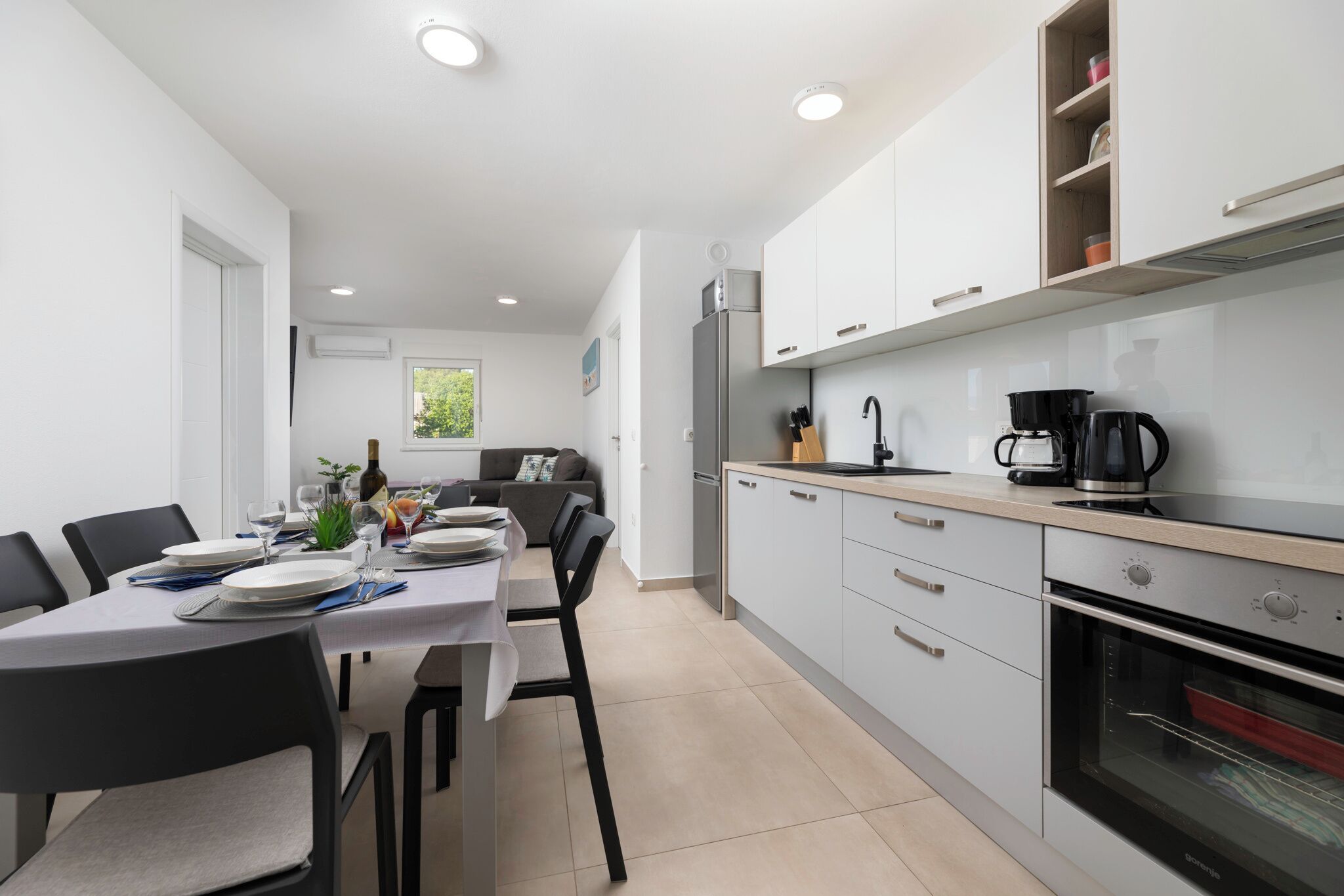 Una cocina moderna con comedor, equipada con refrigerador, estufa y cafetera.