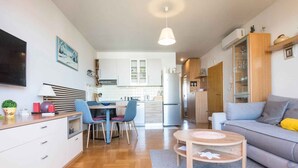 A modern apartment with a dining area, kitchen, and living room. - Holiday apartment with balcony and partial sea view (Biograd na Moru)