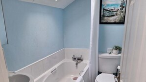 A bathroom with a bathtub, toilet, sink, and a skylight. - Lavender Cottage - a beautiful quirky cottage (Snainton)
