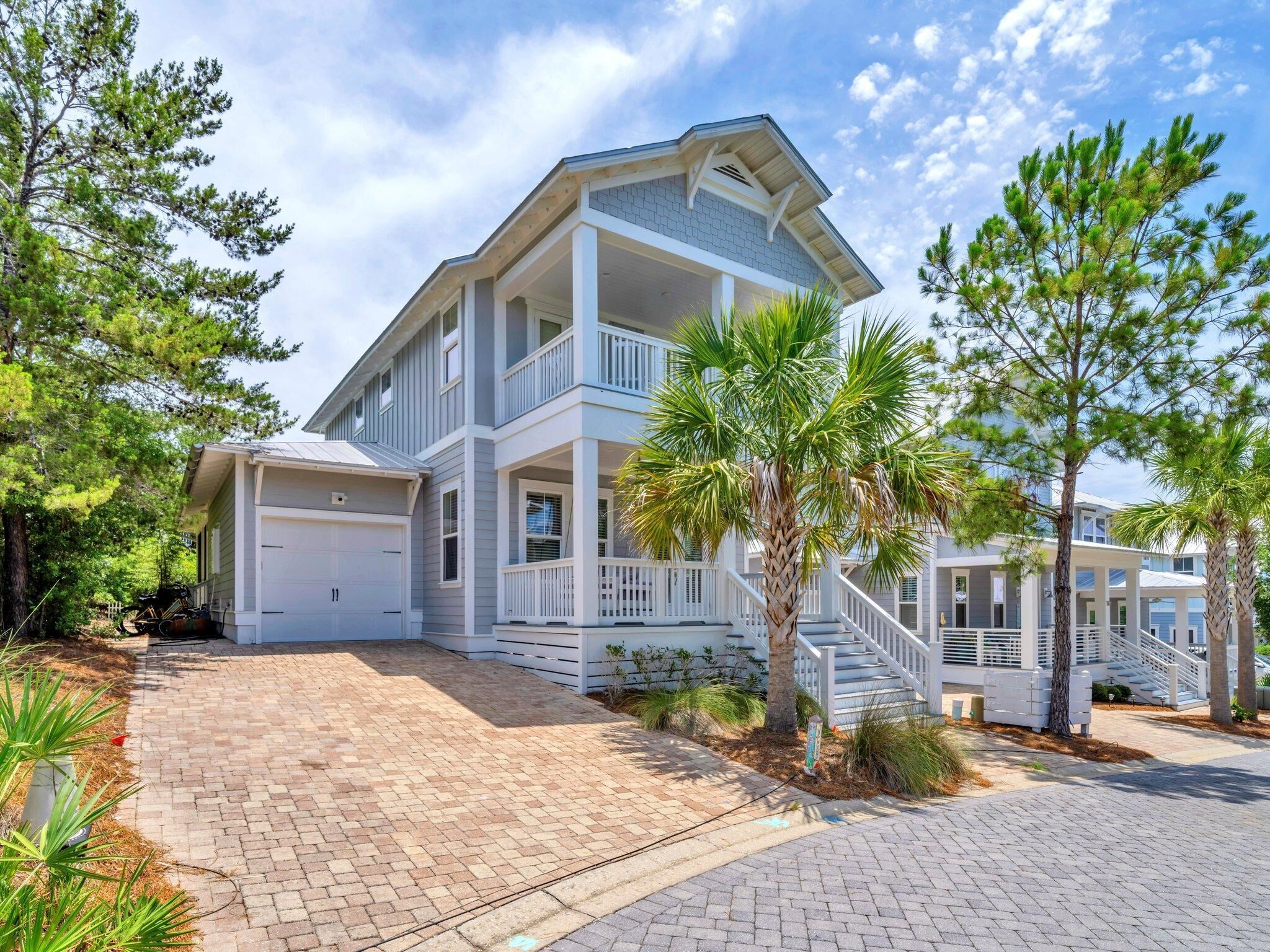A two-story house with a covered porch, a garage, and a staircase leading to the upper level.
