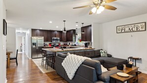 A modern kitchen with dark wood cabinets, stainless steel appliances, and pendant lighting. - Perfect Location, Private Pool and Tiki bar fenced in yard, close to Dollywood (Sevierville)