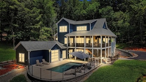 Una casa de dues plantes amb una gran terrassa i una piscina.