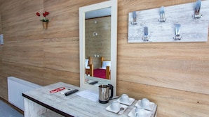 A hotel bathroom with a wooden wall, a mirror, a sink with toiletries, and a towel rack. - Hotel Dimasi (Kutaisi)