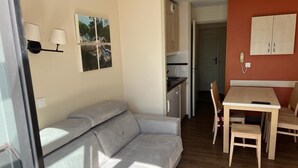 A compact living space with a sofa, a dining table, and a kitchen area. - Comfortable apartment in Cannes (Cannes)