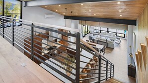 A modern interior with a staircase, wooden ceiling, and a view of a dining area. - Sequoia Chalet | 5BR Vail Luxury Retreat, AC, Hot Tub, Views (Vail)