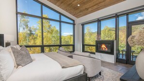 A bedroom with a large bed, a sofa, and a fireplace. - Sequoia Chalet | 5BR Vail Luxury Retreat, AC, Hot Tub, Views (Vail)