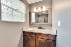 Un baño con tocador, lavabo y espejo.