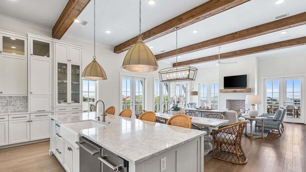 A spacious kitchen with a large island, wooden beams, and a dining area with wicker chairs. - Loaded Designer Home with Gulf and Lake Views, Elevator, Heated Pool, and More (Santa Rosa Beach)