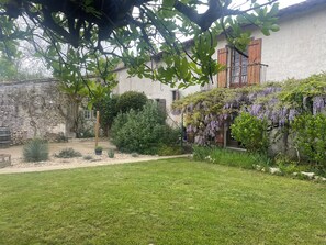 Enjoy a serene outdoor space surrounded by lush plants and a beautifully manicured lawn.