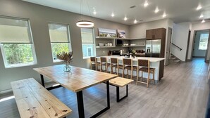 A modern kitchen with a central island, wooden dining table, and chairs. - North Firefly - Resort Pool, 2-min. walk to Private Beach! (Saint Teresa)