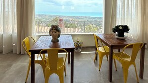A dining area with a table and chairs, a vase, and a view of the landscape. - La casa di Pippo Flora (Agrigento)