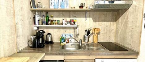 Uma cozinha compacta com lava-louças, máquina de lavar roupa e um balcão pequeno.