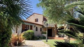 A building with a stone pathway leading to a door, surrounded by greenery and a clear sky. - Vrbo Property
(Laroque-des-Albères)