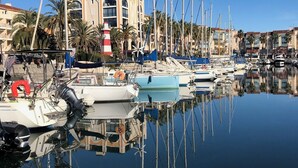 A marina with boats docked, a lighthouse, and a building with multiple floors and balconies. - Vrbo Property
(Laroque-des-Albères)