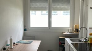 Une cuisine compacte avec une fenêtre, un évier et un coin repas équipé d’une banquette.