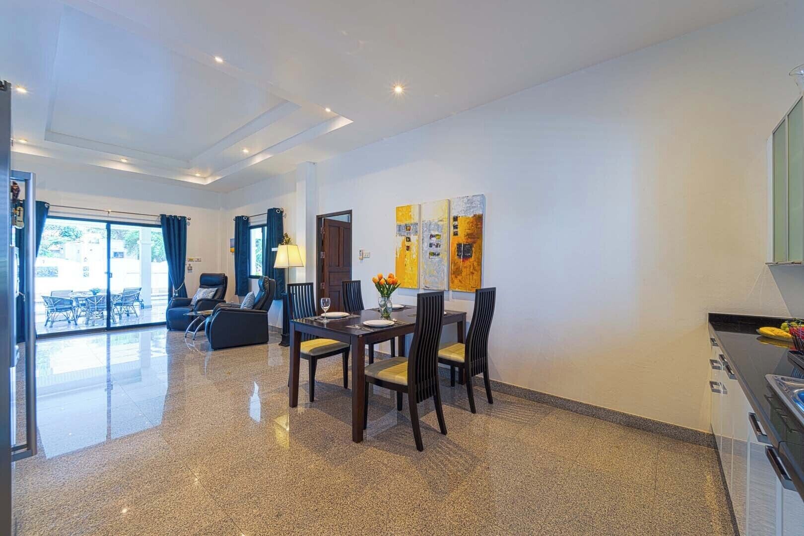 Moderni hotellihuone, jossa on ruokailutila, sohva ja näkymä ulos.