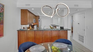 Una cocina moderna con armarios de madera, una isla de vidrio y una lámpara de techo circular original.