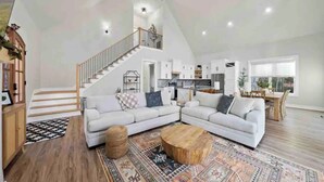 A spacious loft with a large living area, a kitchen, and a staircase leading to an upper level. - Jewel of the Hidden Cove (Littleton)