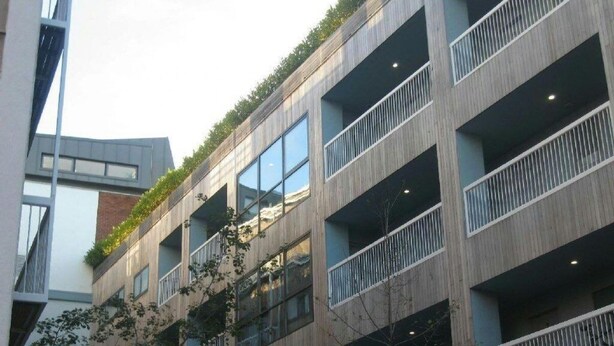 Un edificio de varios pisos con balcones, ventanas amplias y un estilo arquitectónico moderno.