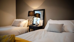 A hotel room with two beds, a nightstand with a lamp, and a mirror. - Liverpool Harrow Road Sleeps 6- Infinity Apartment (Liverpool)