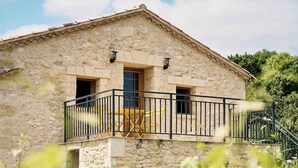 A stone building with a balcony and a door. - Gîte au Cœur des Vignes (Montagne)
