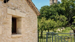 A stone building with a window and a bell tower in the background. - Gîte au Cœur des Vignes (Montagne)