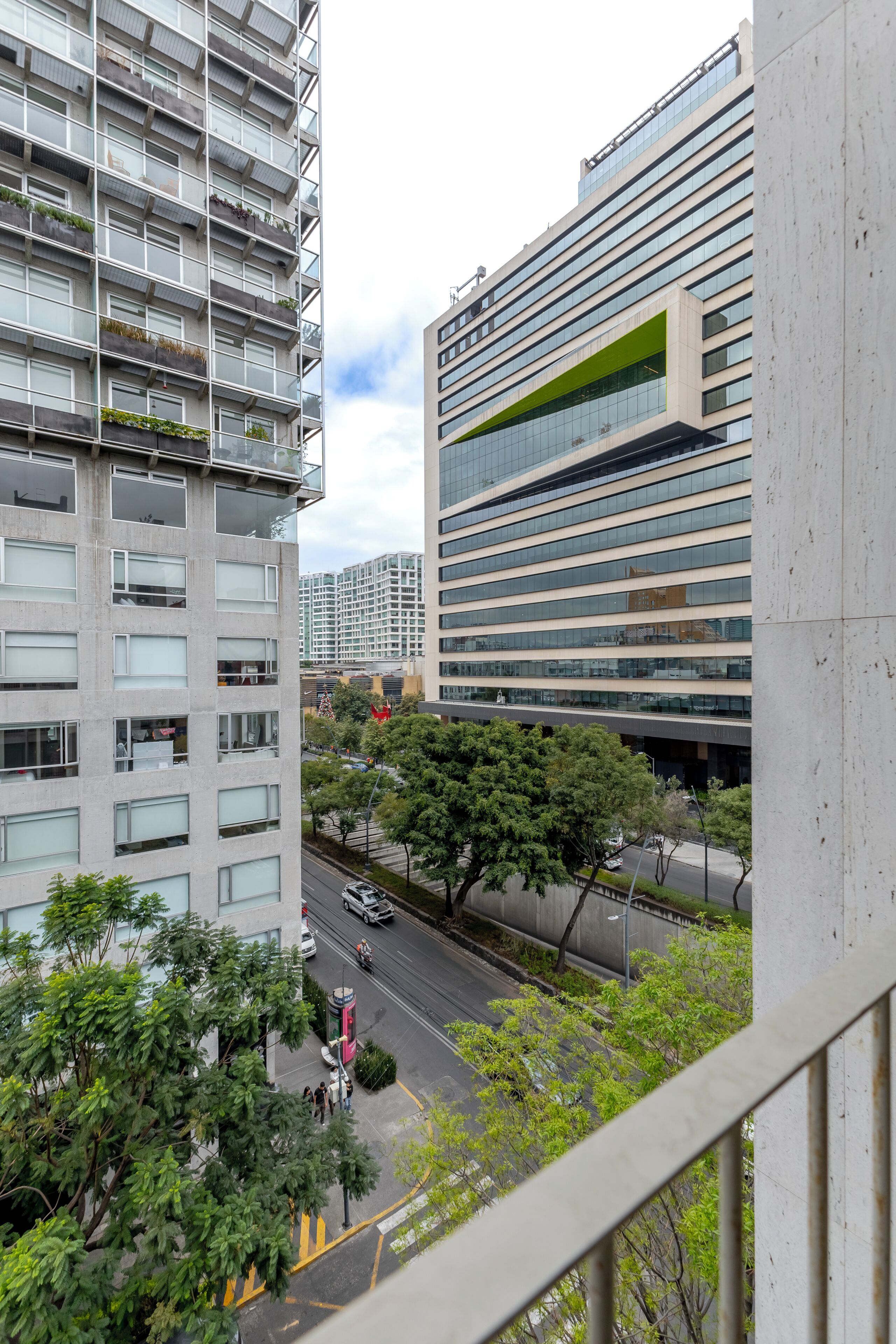 Un edificio de gran altura con varios pisos, ventanas amplias y balcones.