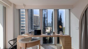 A modern office space with a large desk, a chair, and a laptop.