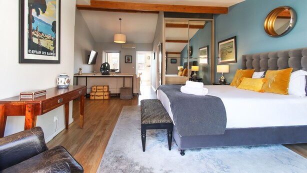 A bedroom with a large bed, a desk, and a mirror. - Principe Real Deluxe by Homing (Lisbon)