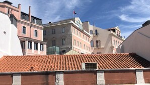 A building with a red-tiled roof and arched windows. - Principe Real Deluxe by Homing (Lisbon)