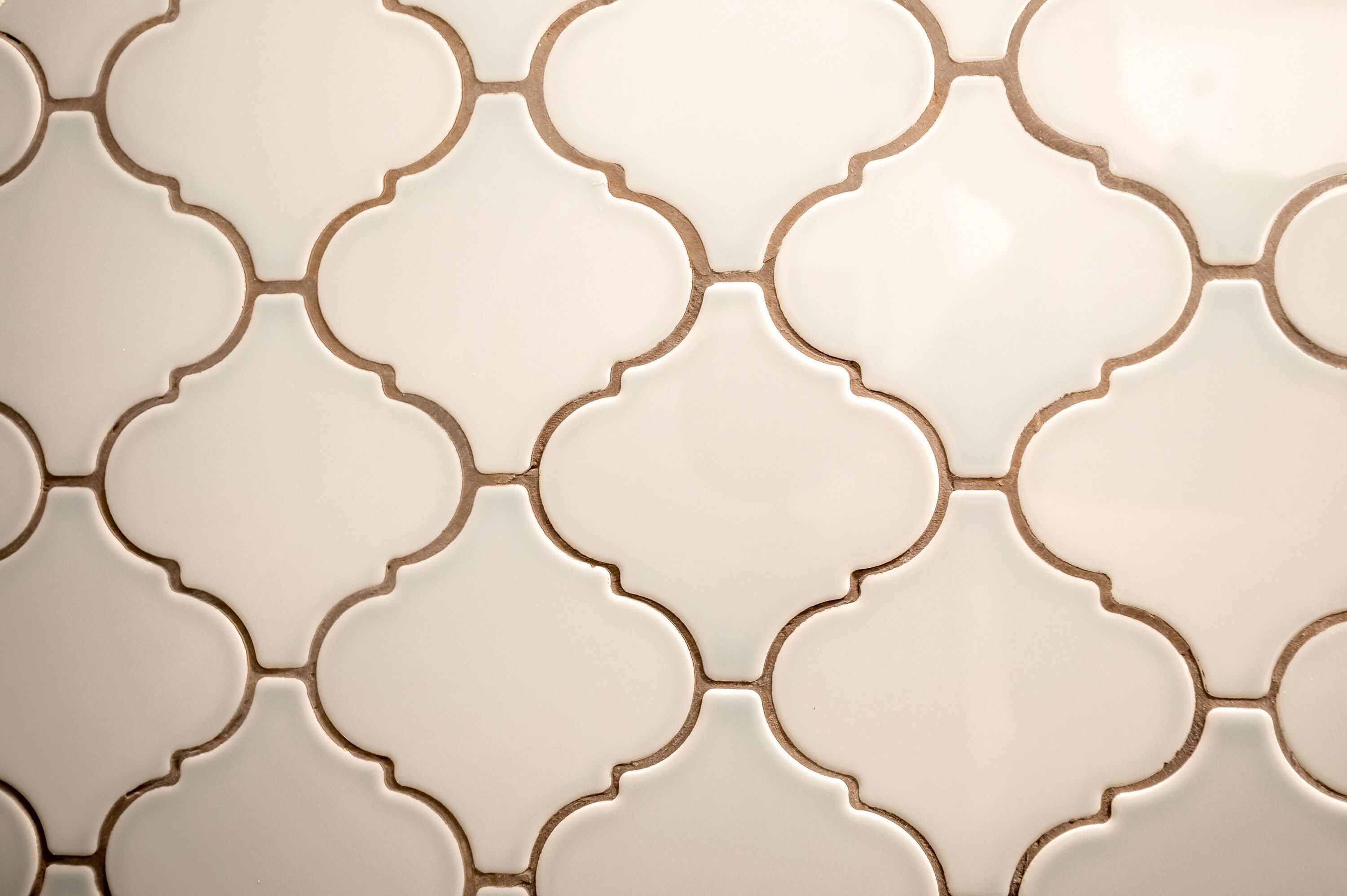 A close-up of a tiled wall with a repeating geometric pattern.