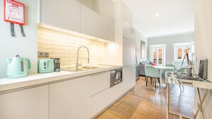 A modern kitchen with a built-in oven, a sink, and a kettle on the counter. - Bairro Alto Prime Duplex by Homing (Lisbon)