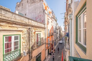 Eine enge Straße mit Gebäuden, die Balkone und traditionelle Architektur aufweisen.