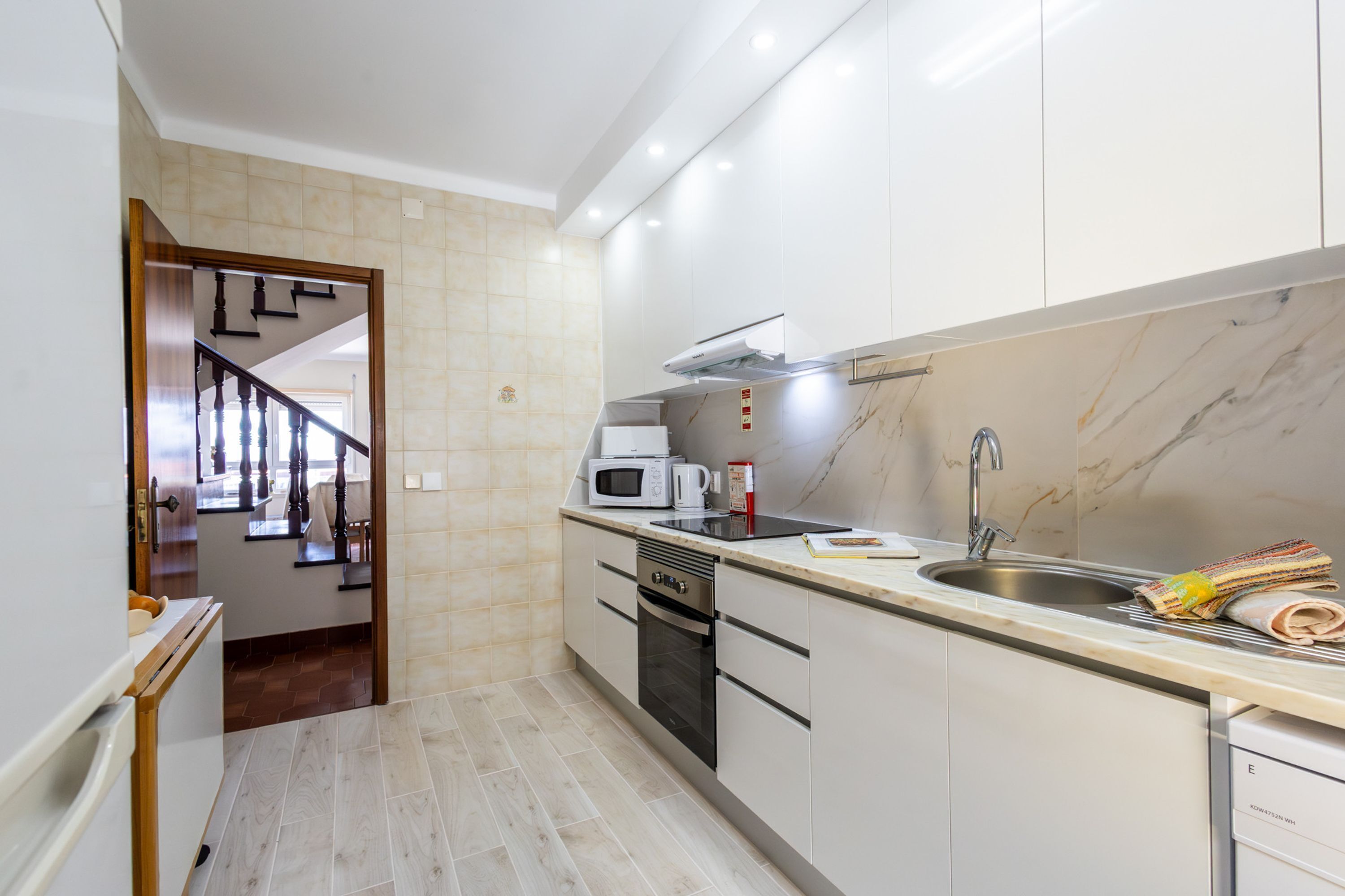 A modern kitchen with a built-in oven, microwave, and sink.