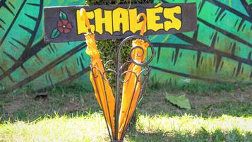 A sign with the word 'CHALLES' and a flower design, mounted on a metal structure with two umbrellas.