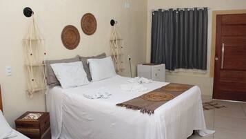 A bedroom with a bed, bedside tables, a wardrobe, and a window with curtains.