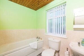 Un baño con bañera, inodoro y lavabo.