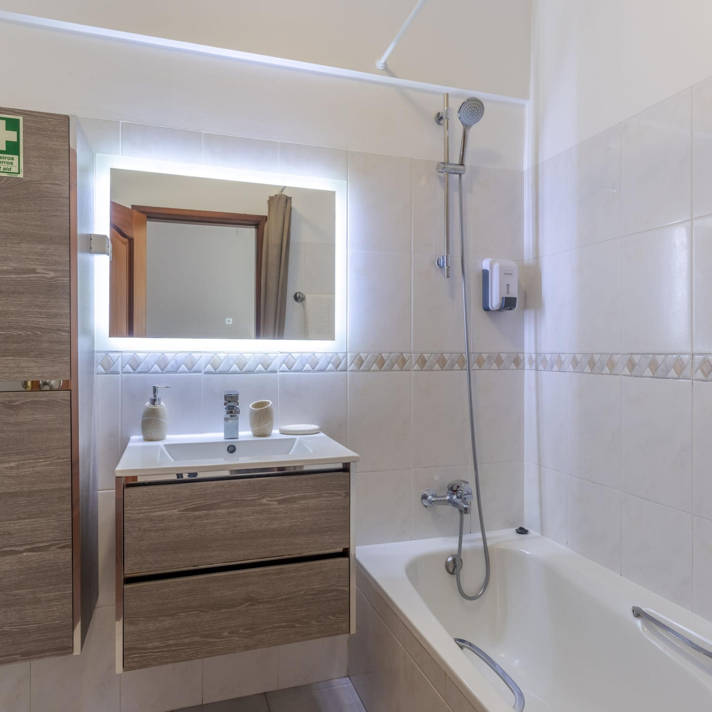 A bathroom with a bathtub, a sink with a mirror above it, and a shower.