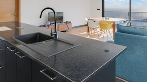 A modern kitchen with a built-in sink and a dining area with a view. - Casa Mozart II 15B in Estreito da Calheta (Calheta)