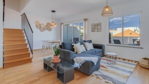 Un salon moderne avec un canapé, une table basse et un escalier.