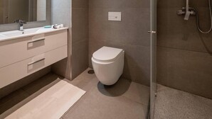 Un baño moderno con ducha, inodoro y lavamanos.