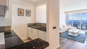 Un apartamento moderno con cocina, sala de estar y balcón con vistas.
