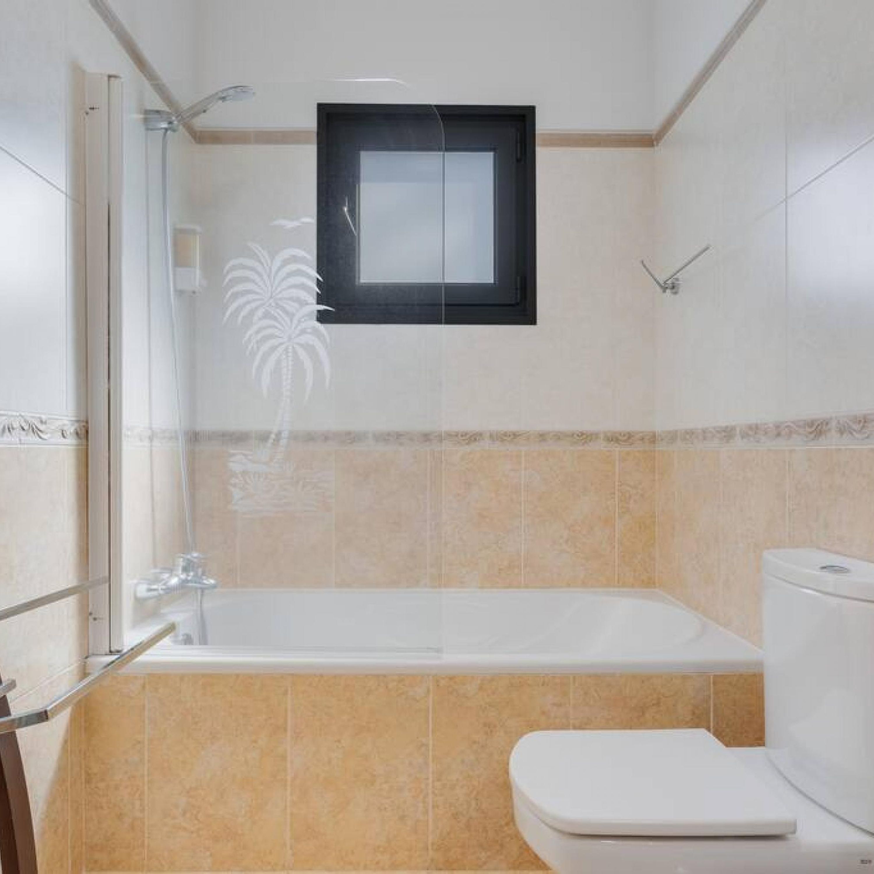 A bathroom with a bathtub, toilet, and a shower enclosure.