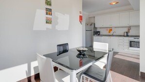 A modern kitchen with white cabinets, a stainless steel refrigerator, and a coffee machine. - Anje Apartamento 4 Q (Funchal)