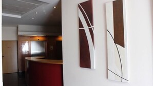 En modern entréhall med en böjd receptionsdisk, abstrakt väggkonst och en stilren, minimalistisk design.