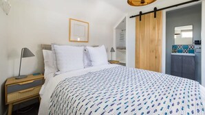A bedroom with a bed, bedside tables, a hanging light fixture, a wardrobe, and a framed picture on the wall. - Lavender Folly - Cosy Accommodation Alresford (Alresford)