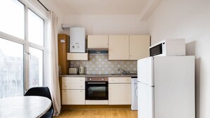 Eine kleine Küche mit Herd, Mikrowelle und Kühlschrank.
