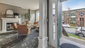 A hotel lobby with a fireplace, seating area, and a view of the street. - The Orenco Station Hotel (Hillsboro)