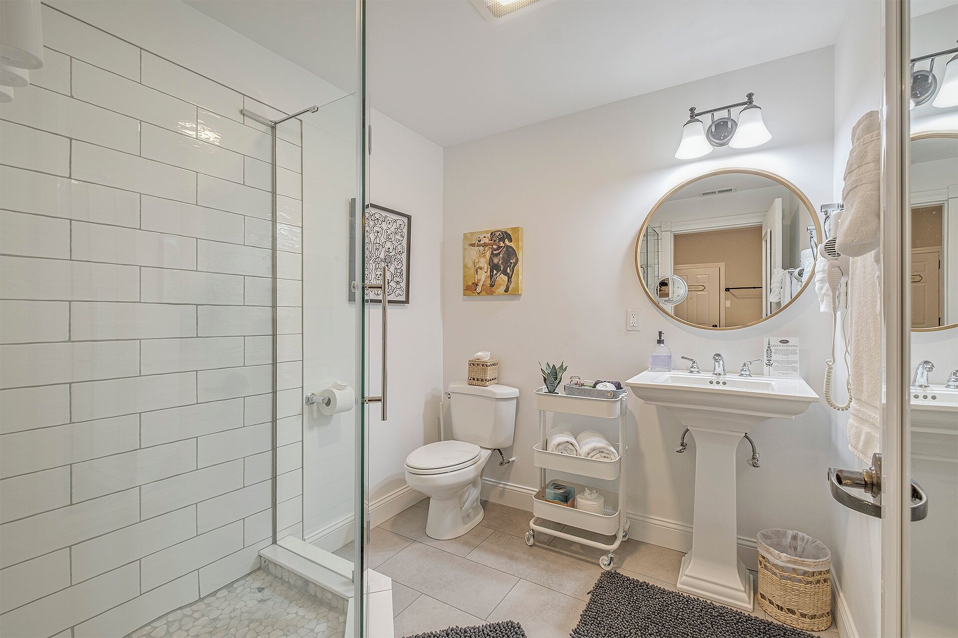 Une salle de bain moderne avec une douche à parois de verre, des toilettes, un lavabo avec un meuble-vasque et un grand miroir.