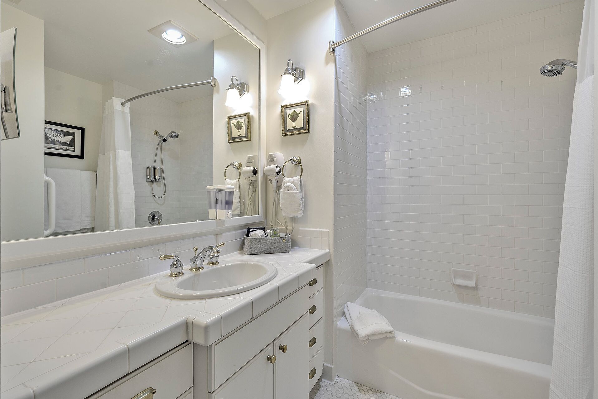 Un baño con bañera, lavabo, espejo y ducha.